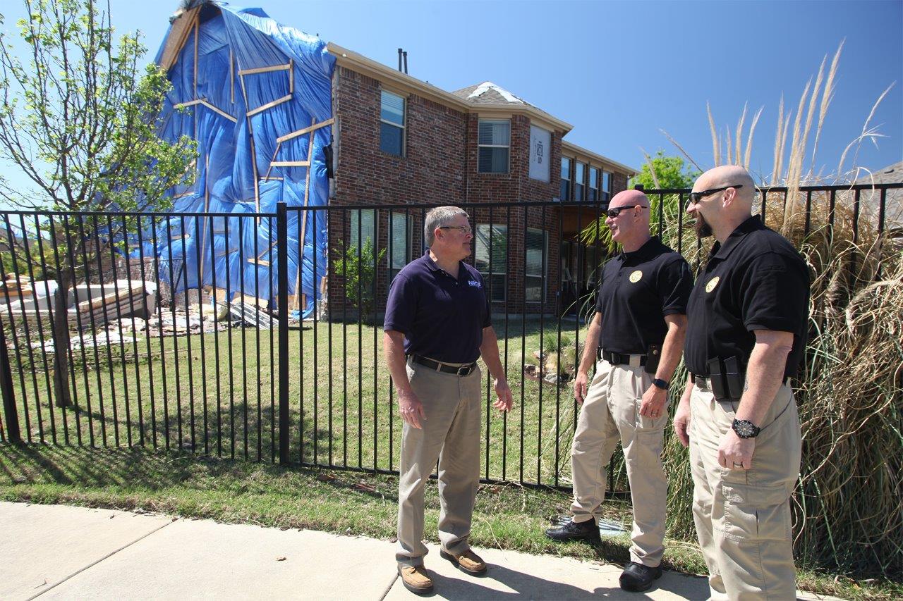 NICB and Texas Department of Insurance Fraud Investigators talking in front of fence