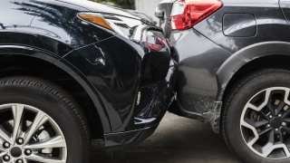 Black car hitting grey car from behind
